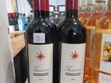 trois bouteilles de vin posées sur le comptoir d'un magasin