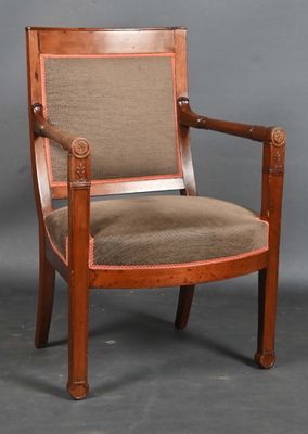an old wooden chair with a tan upholstered seat