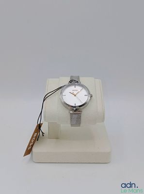 une photo d'une montre posée sur un présentoir, avec une étiquette accrochée dessus