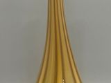 a gold vase that is sitting on a white surface