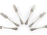 six fourchettes disposées en cercle sur une surface blanche