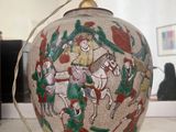 un vase avec un tableau posé sur une table