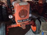 a red tractor that is parked in a garage