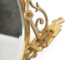 a mirror with a gold frame and a bird on it