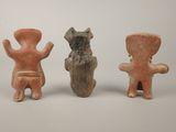 three small clay figurines of a man and a dog