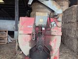 a large bale of hay in a barn next to a machine