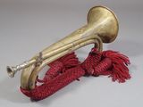 a brass trumpet with a red rope around it