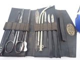 a leather case with tools in it on a white surface