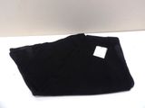the black pants are folded up on a white surface