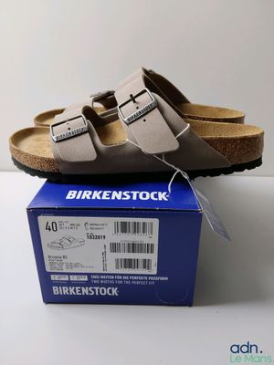un gros plan sur une paire de sandales Birkenstock posées sur une boîte