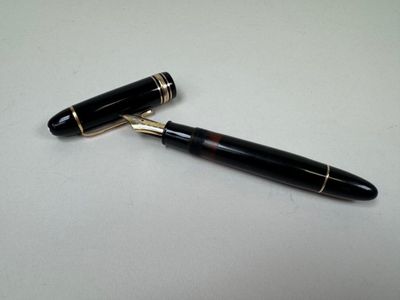 a close up of a pen on a table with a white background