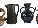 four different vases sitting next to each other on a white surface