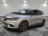 Une voiture argentée est garée sur un sol à damier dans une pièce