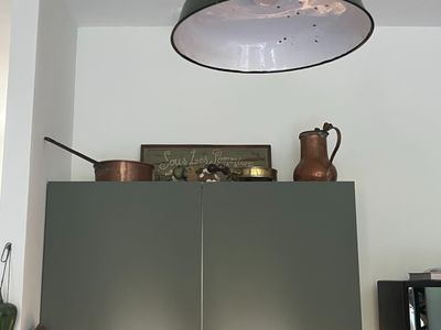 a picture of a kitchen with a large light above it