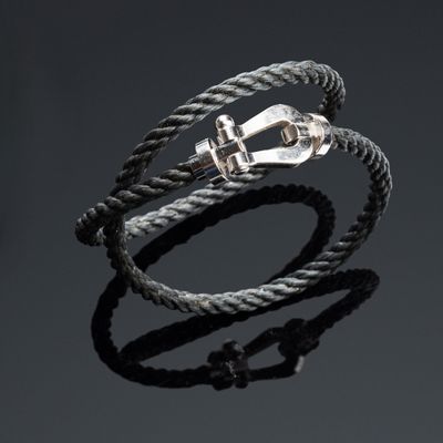 a close up of a rope bracelet with a silver clasp