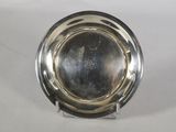 un plateau d'argent antique sur un support sur une surface blanche