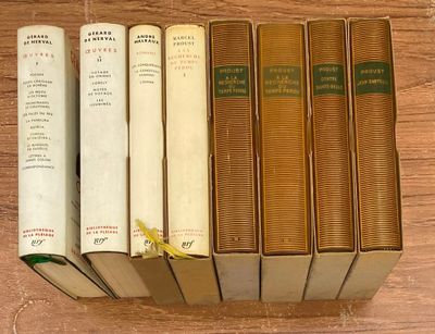 Plusieurs vieux livres sont alignés sur une table en bois
