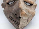 an old wooden mask on a white surface with a white background