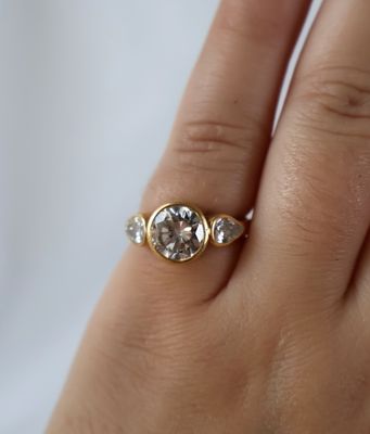 la main d'une femme tenant une bague sertie d'un diamant