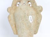 a stone vase with a bird head on it