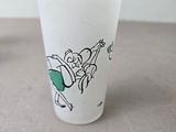 a glass with a horse drawn on it sitting on a table