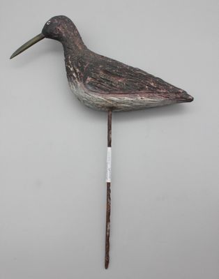une image représentant un oiseau en bois au long bec, fixé sur un bâton