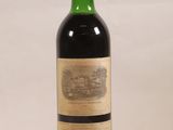 une bouteille de vin rouge posée sur une table blanche