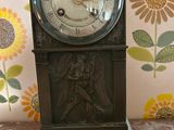 a clock that is sitting on a table with flowers in the background