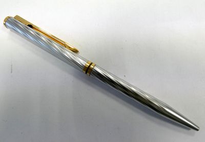 a close up of a pen sitting on top of a white surface