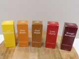 four boxes of perfume sitting on top of a wooden table