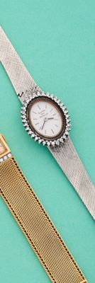 deux montres posées l'une à côté de l'autre sur une surface bleue
