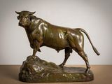 bronze statue of a bull standing on a rock on a table