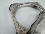 a silver spoon with a handle on a white table