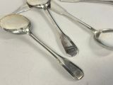 three spoons and a spoon rest on a white surface