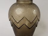 a brown vase with a chevroned design on it