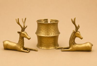 deux figurines de cerfs en or posées l'une à côté de l'autre sur une table