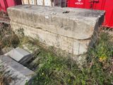 a concrete block sitting in the grass next to a red box