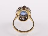 a close up of a gold ring with a blue topaz stone