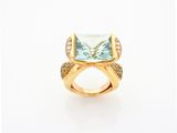 a close up of a gold ring with a blue topaz stone