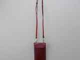 an image of a red purse hanging on a white wall