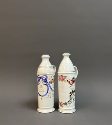 two white vases with floral designs on them sitting next to each other
