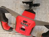 a red and black cordless saw on the floor