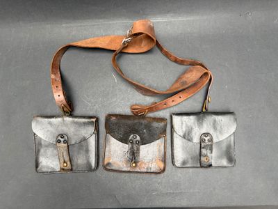 trois morceaux de cuir posés sur une table, maintenus par une lanière en cuir
