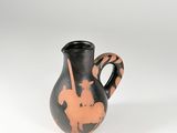 vase noir et orange posé sur une surface blanche, sur fond blanc