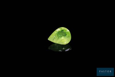 gros plan d'un diamant vert sur une surface noire