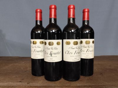 three bottles of red wine are lined up on a wooden table