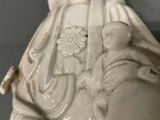 a statue of a woman holding a flower in her hand