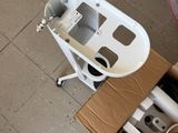 a small white machine sitting on the floor next to a cardboard box
