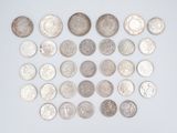 a lot of silver coins on a white surface