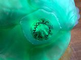 a close up view of a green vase with a label on it
